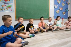 Kinds sitting in circle at music class