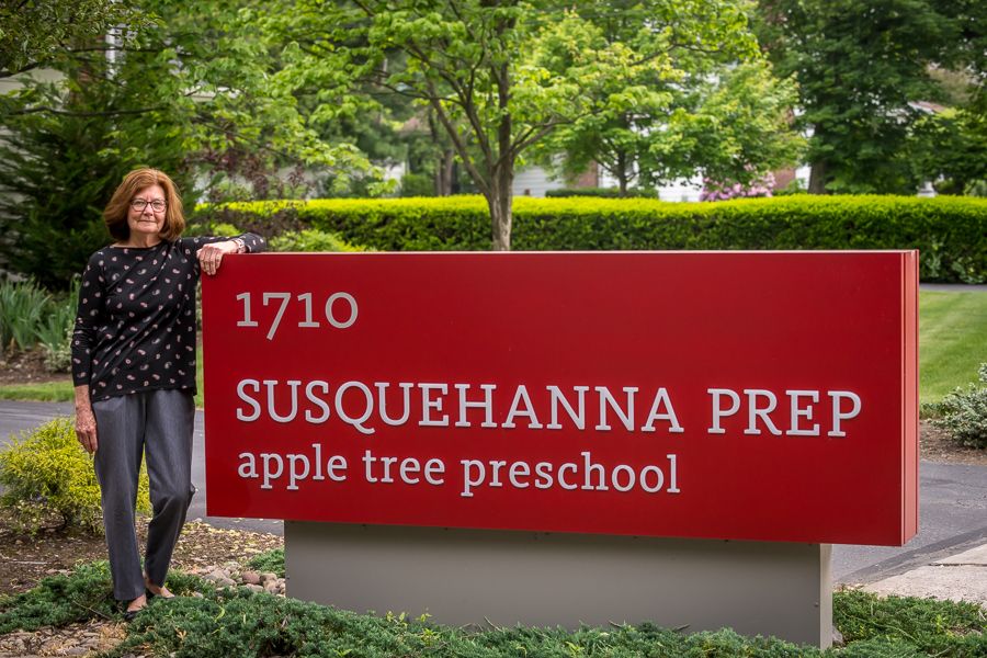 director standing by school sign